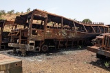 Image showing school buses that have been left charred and destroyed by the recent conflict.